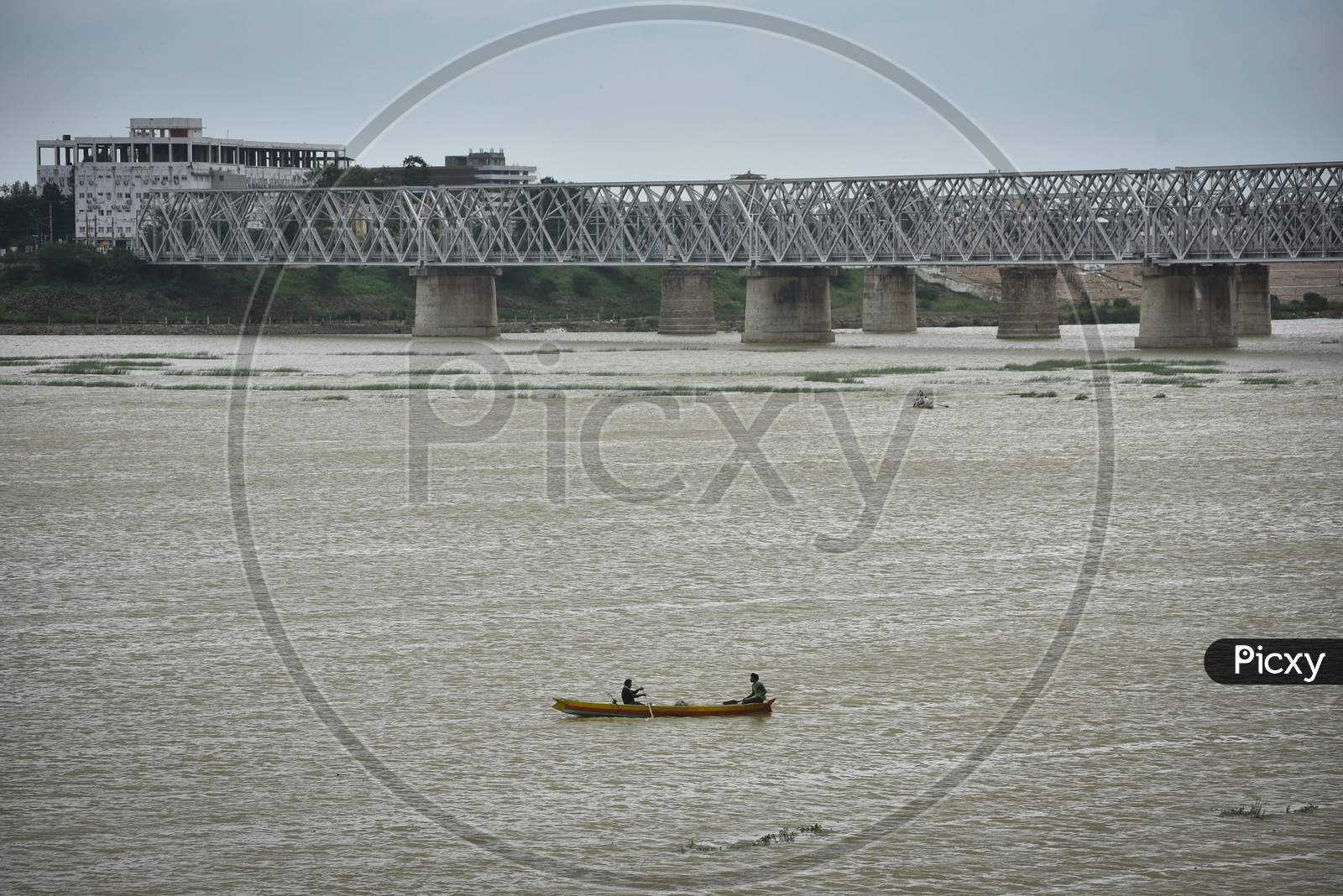 Fishermen Row Their Boat In The Krishna River As Surplus Water Released From The Prakasam Barrage Following Heavy Rains, In Vijayawada On August 13, 2020.