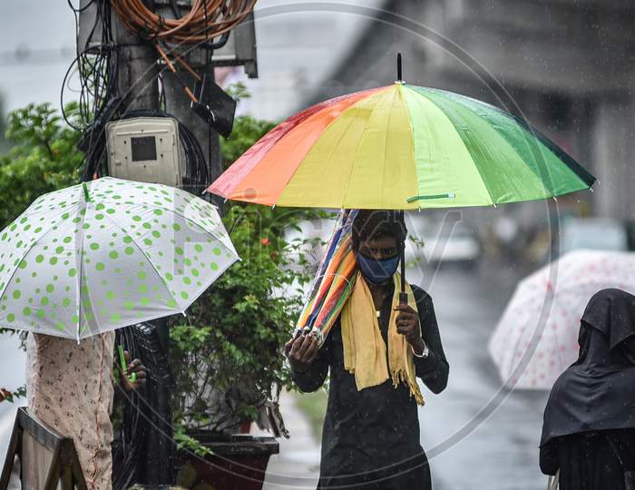 A Man Sells Umbrellas During The Rain, At Benz Circle, In Vijayawada On August 15, 2020.