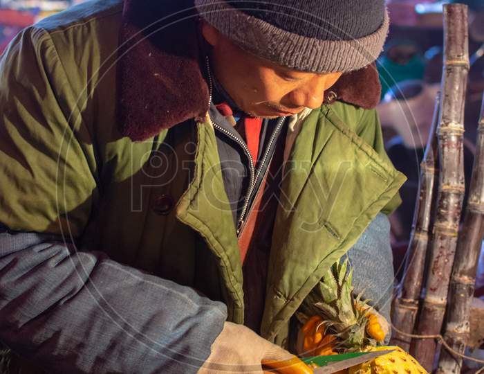 Man Cutting And Selling Pineapple On Street Food Fruit Stall In Luoyang, China