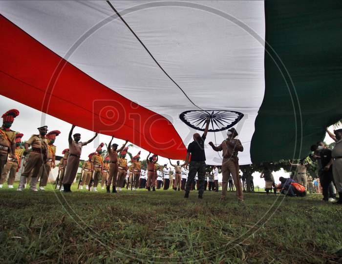Policemen open a 100ft Tricolor Flag for flag hoisting function for Independence Day celebrations in Mumbai, India, August 15, 2020.