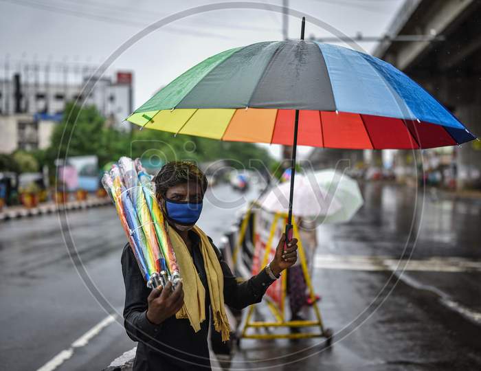 A Man Sells Umbrellas During The Rain, At Benz Circle, In Vijayawada On August 15, 2020.