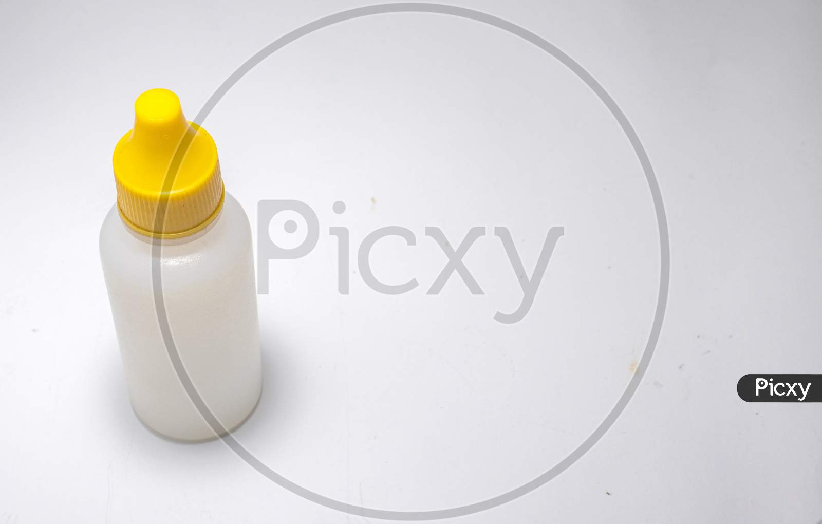 White Bottle With Yellow Cap On A White Background.