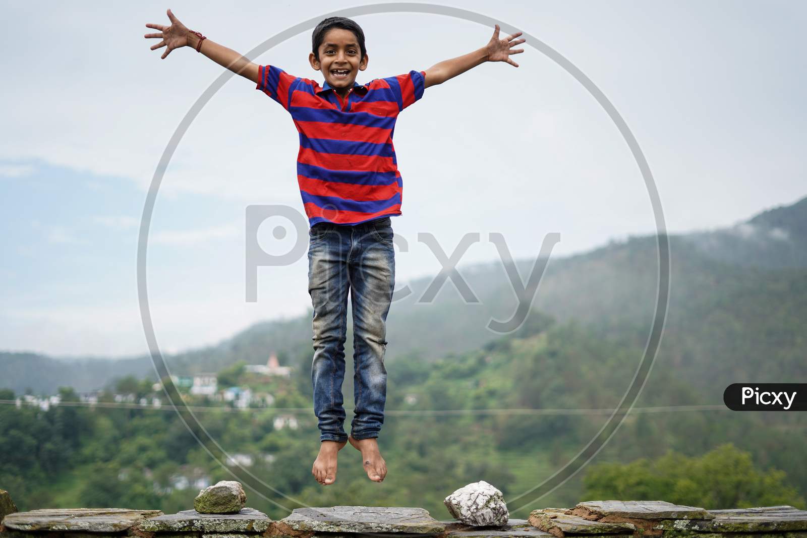 Little Indian Kid Jumping With Joy On The Roof