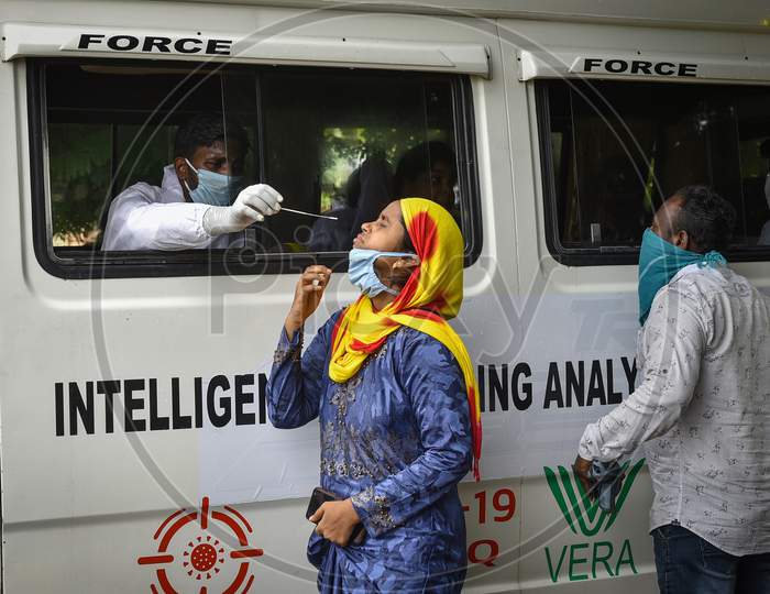 A Medic Collects A Nasal Sample Of A Woman For The Covid-19 Test From A Mobile Swab Collection Vehicle, In Vijayawada On August 12, 2020.