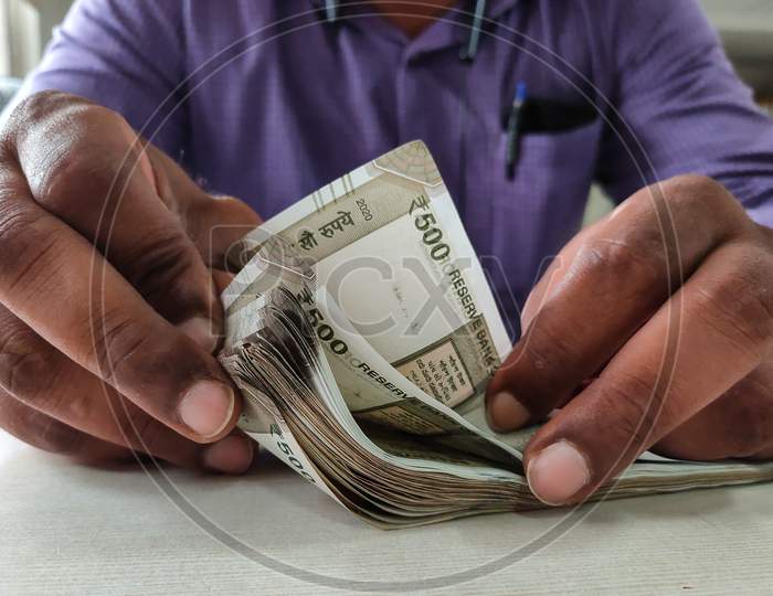 Man Counting Indian Currency With Hands.