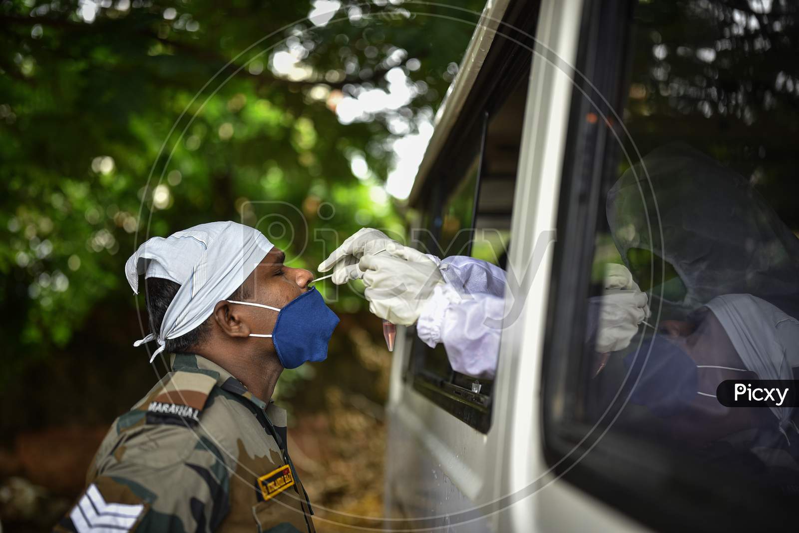 A medic collects a nasal sample of an army soldier for the COVID-19 test, In Vijayawada On August 12, 2020.