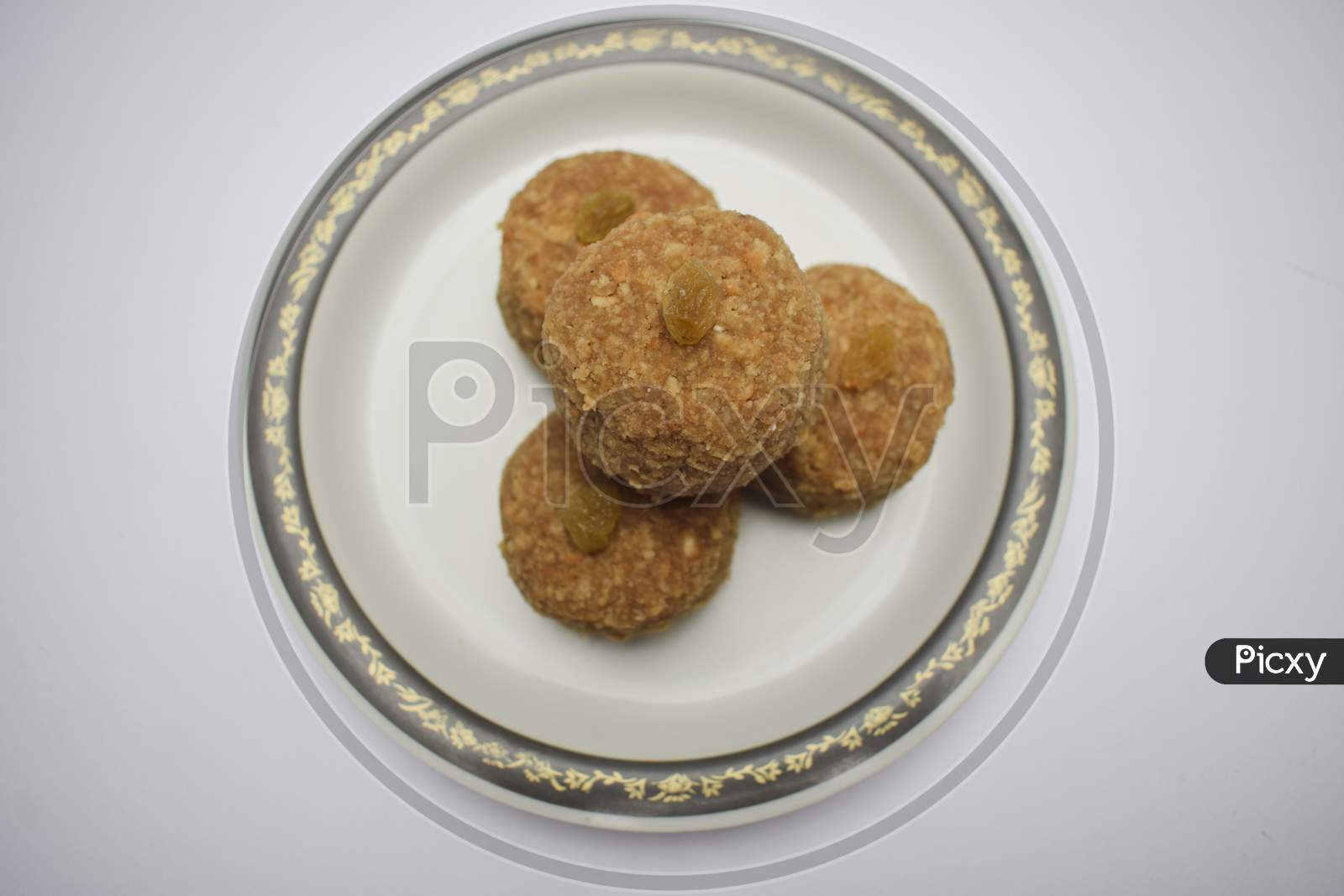 Home Cooked Indian Sweet Dish Laddu, Ladoo Made Of Wheat Flour And Clarified Butter Ghee Served In Plate During Indian Festivals Like Ganesh Chaturthi Prashad Garnished With Raisin