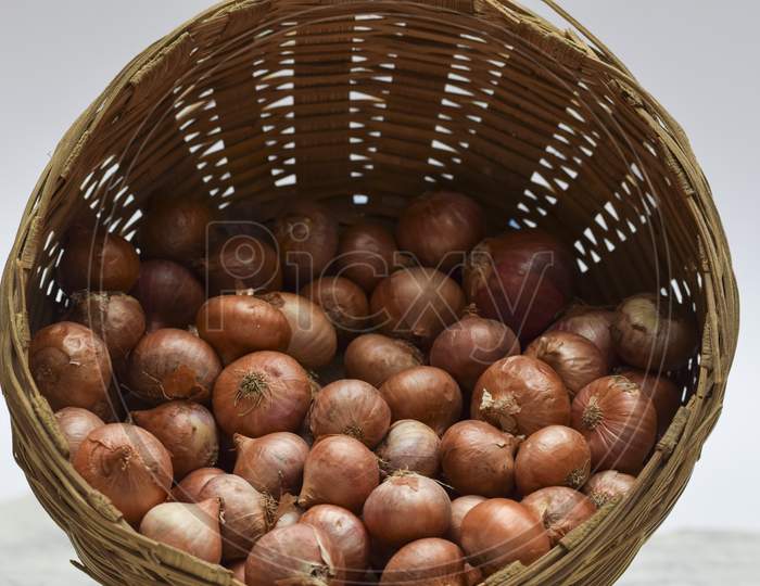 Small Onions Stored In Round Brown Wicker Bamboo Basket In Indian And Pakistani Household.