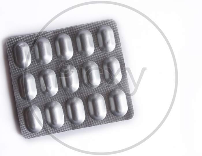 Pills In Silver Packaging On White Background..