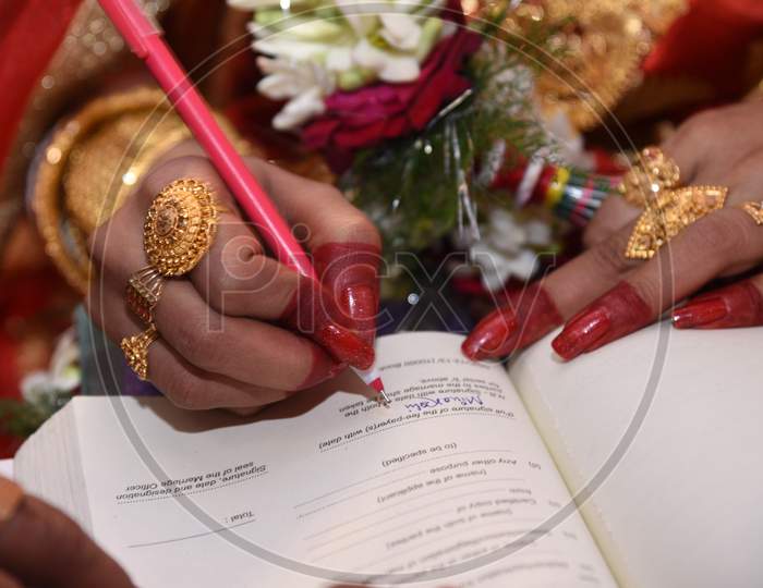 Bride Doing Signature On Marriage Register In India,