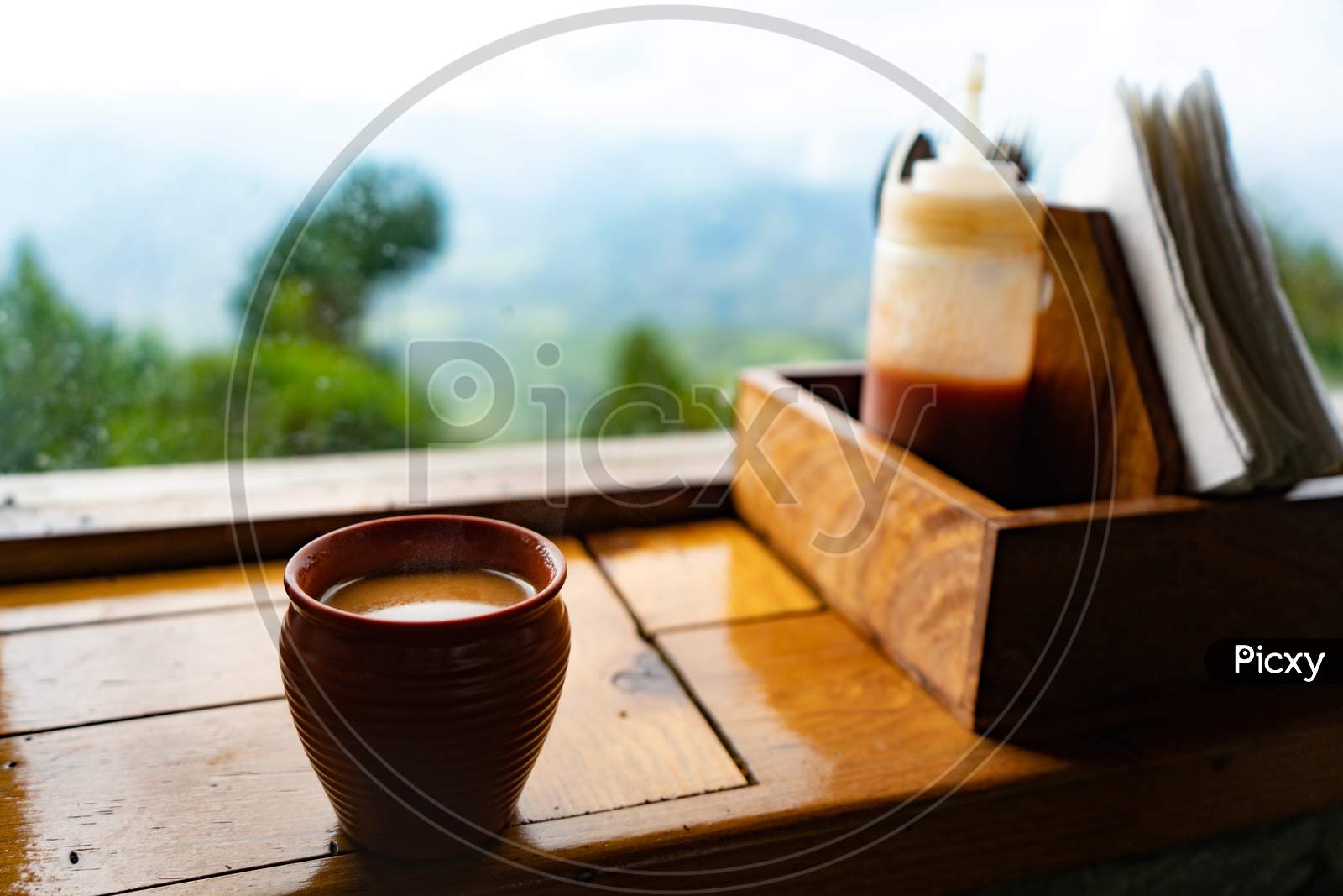 A Kullad Full Of Tea Kept On The Window With A Great View Of Mountains.