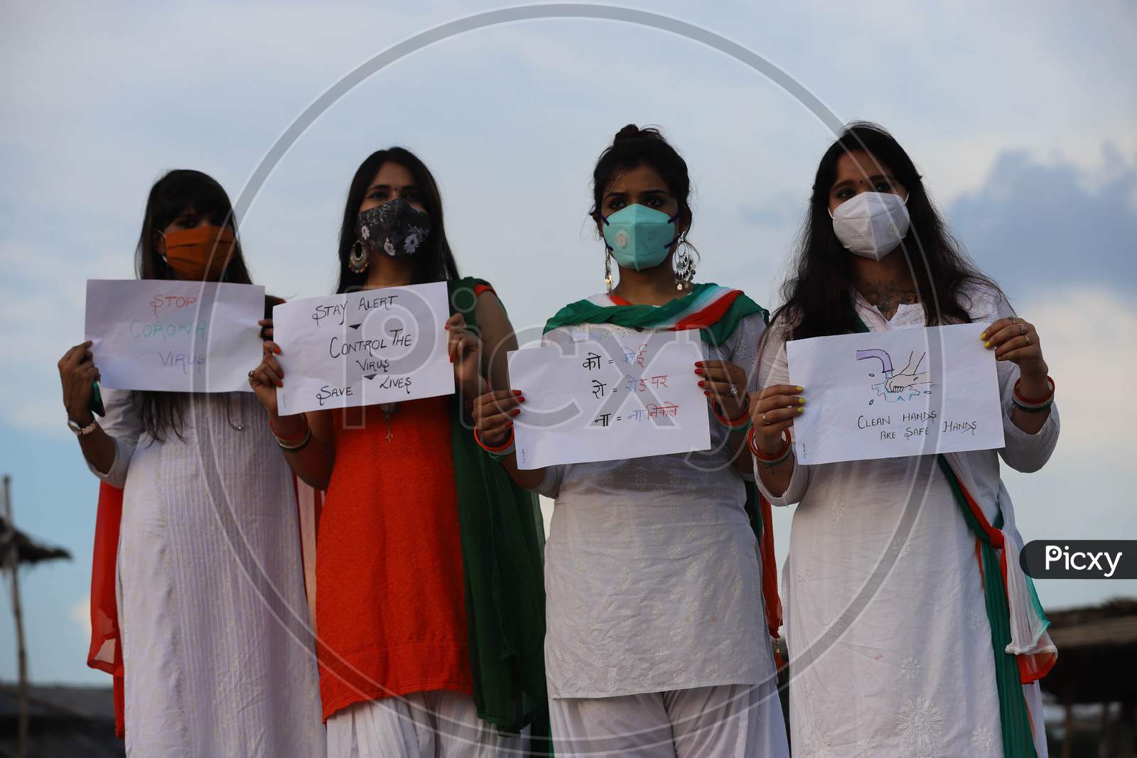 Women hold posters with messages to celebrate Independence day on the river bank of Sangam in Prayagraj, August 15, 2020.