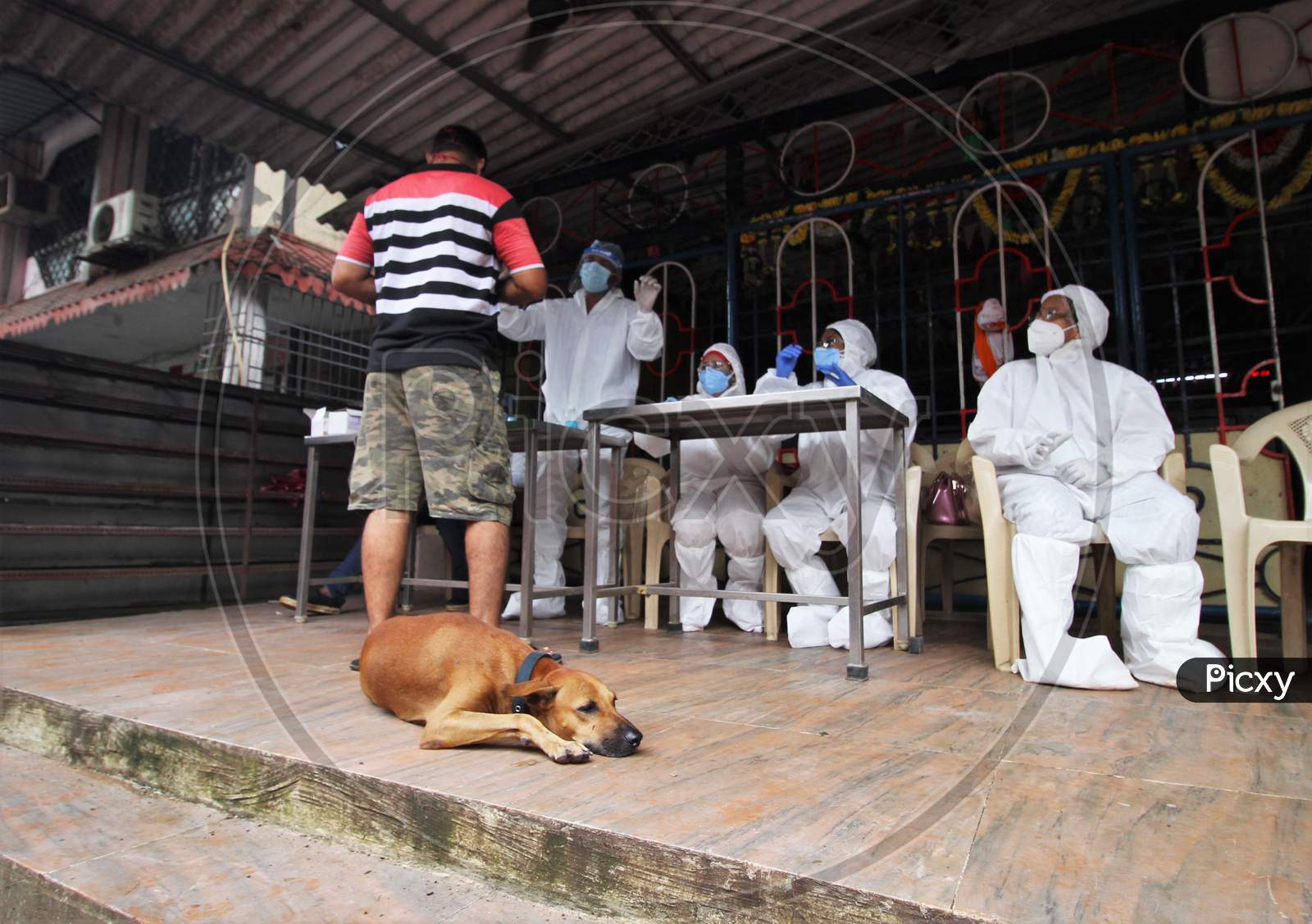 Healthcare workers wearing personal protective equipment(PPE) conduct a check up campaign for the coronavirus disease (COVID-19) , at the entrance of a temple, in Mumbai, India on August 15, 2020.