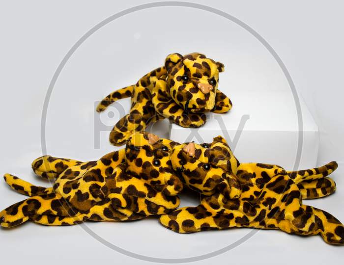 Three Playing Stuffed Leopard Soft Toys Isolated On A Plain White Background