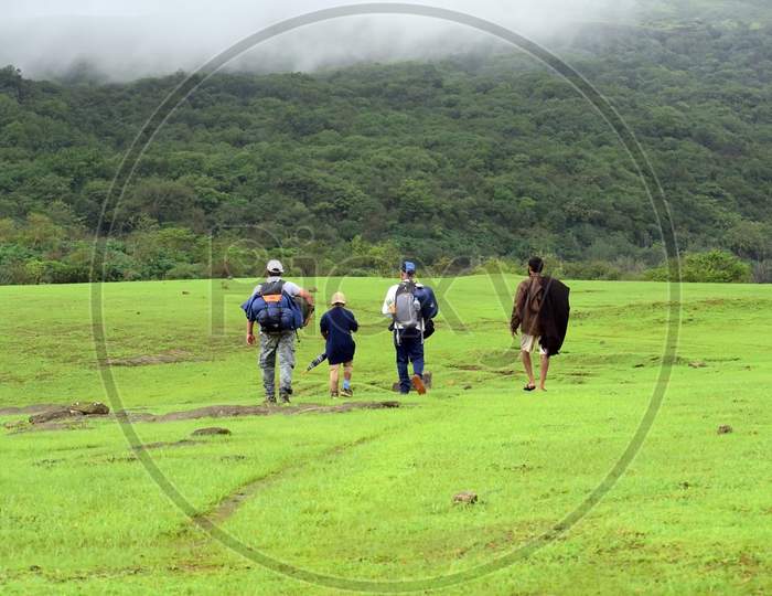 A small group of trekkers on exploration travel in Sahyadri ranges. Monsoon is the best period for trekkers to enjoy nature. Locals help in guiding tourists for jungle routes.