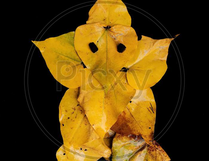 Creative ganpati, Ganesh idol with yellow leaf on black background