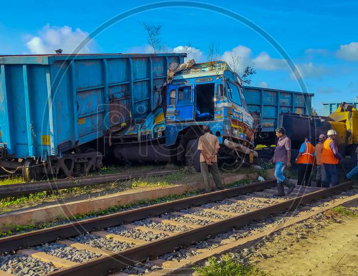 Paradeep, Odisha, India- July 22, 2020: A Rail Accident Near A Construction Site At Paradeep. Rail Wagons Hit A Truck And Has Risen Above It. Workers And A Bulldozer Are Engage For Removing Debris.