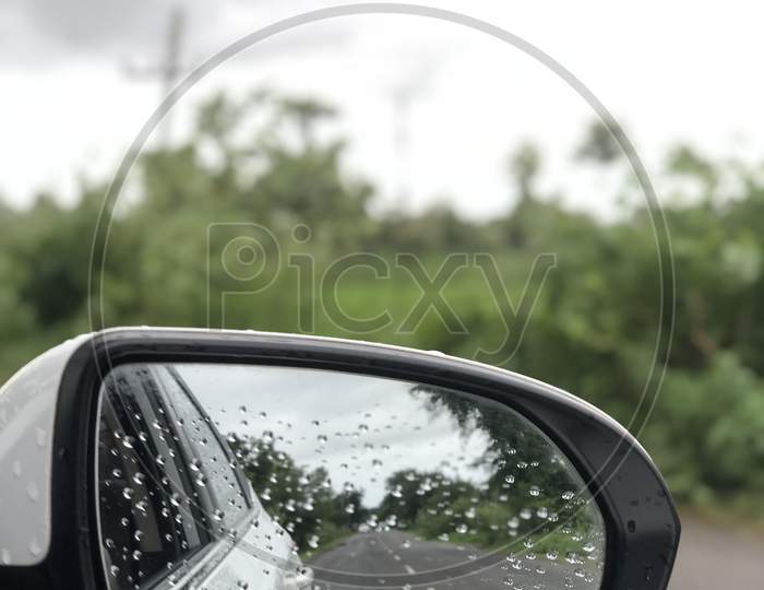 A view of portrait side mirror of a car with nature