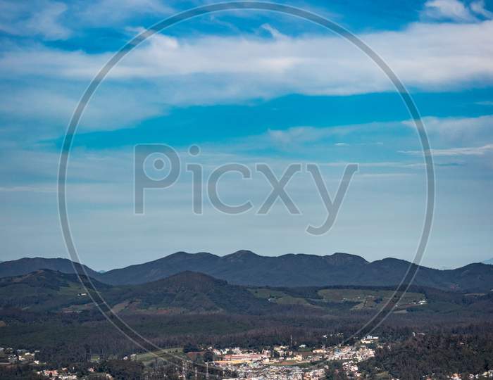 City View With Mountain Range And Bright Blue Sky From Hill Top At Day