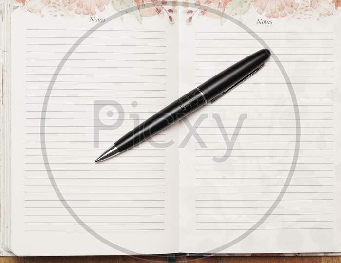 Flat Lay Of Black Pen On Open Agenda. Organization Concept.