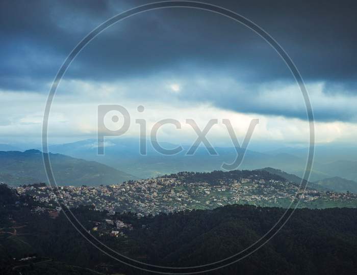 Landscape Of A City Situated On The Top Of The Mountain With Clouds In The Sky.