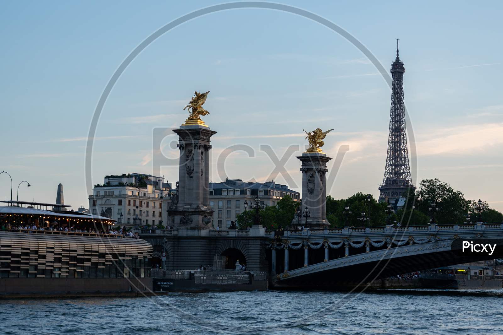 Famous Pont Alexandre Iii, Giant Towers With Gilded Pegasus And Eiffel Tower In Background After Sunset.