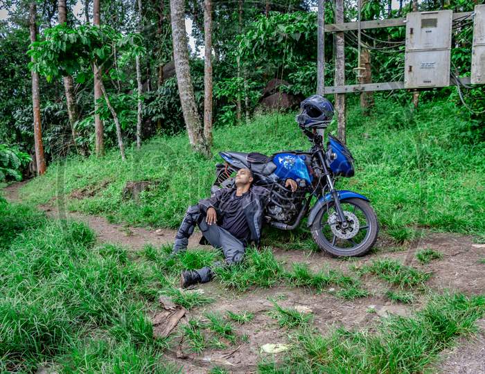 Motorcycle Solo Rider Sitting At Remote Trails With Motorcycle And Helmet