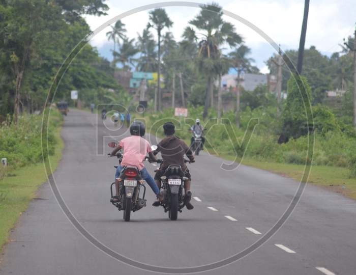 A motorcyclist helping other motorcyclist when out of fuel in Indian village roads