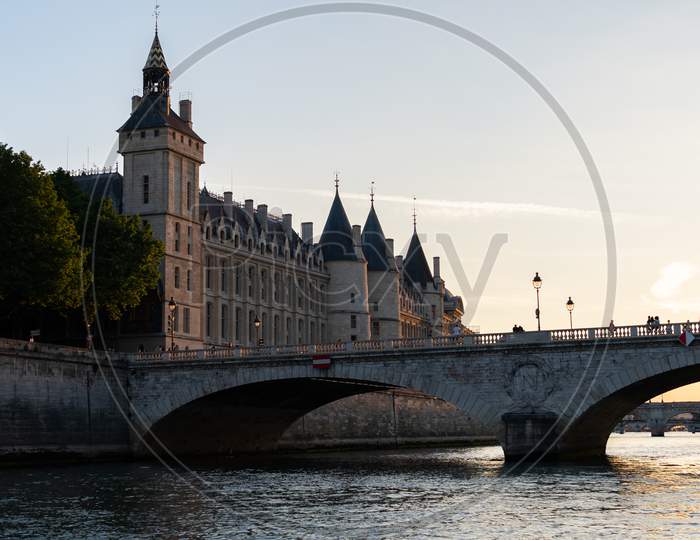 The Conciergerie And The Bridge Pont Au Change Seen From The Seine River In Paris France At Sunset.