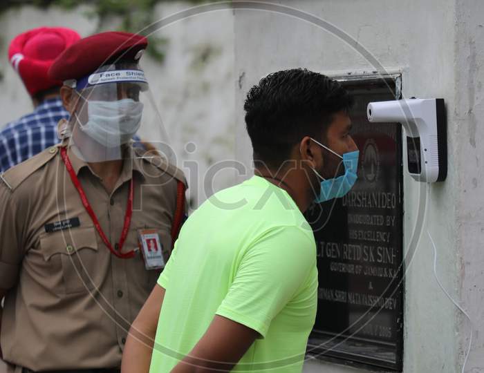 Pilgrims undergo thermal screening at Vaishno Devi  temple after authorities allowed re-opening of religious places in J&K, amid the ongoing COVID-19 pandemic, at Katra in Reasi district,  August. 16, 2020.