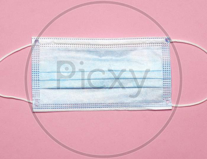 Flat Lay Of Face Mask On Pink Background. Covid 19