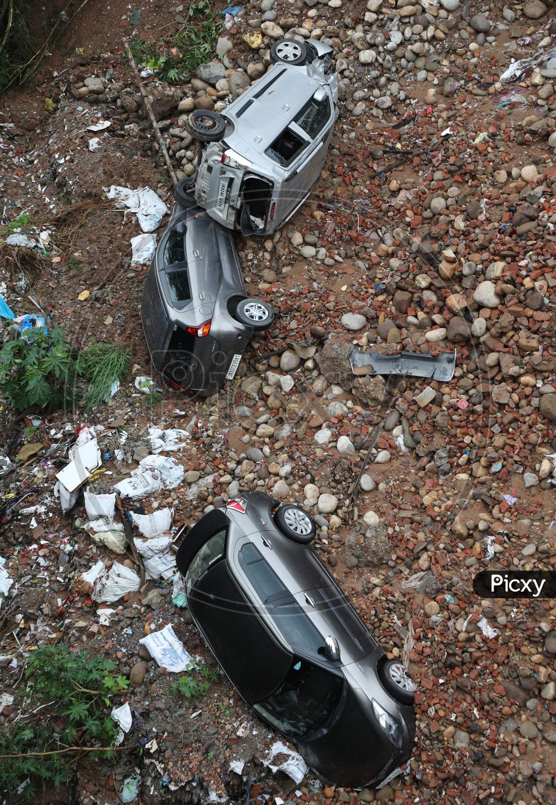Vehicles lying damaged in a ditch after heavy rains resulted in sinking of a roadside along circular road connecting Panjtirthi with Gujjar Nagar in Jammu city  on August 17,2020.