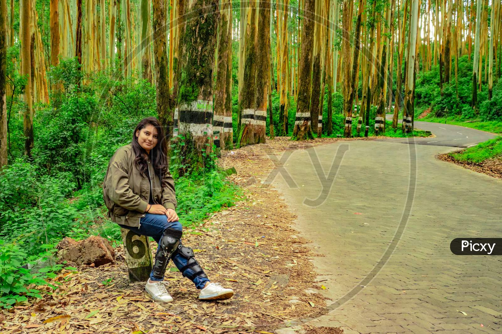 Girl Isolated On Empty Tarmac Road With Lush Green Forest