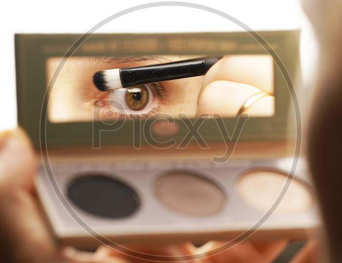 Woman'S Eye Reflected In Makeup Kit Mirror. Fashion Makeup Concept