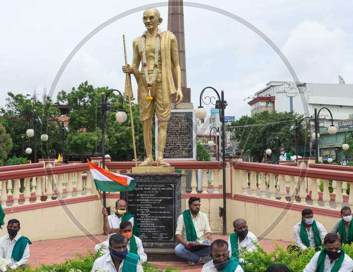 Farmers sitting under Mahatma Gandhi statue at Mysore/Karnataka/India.