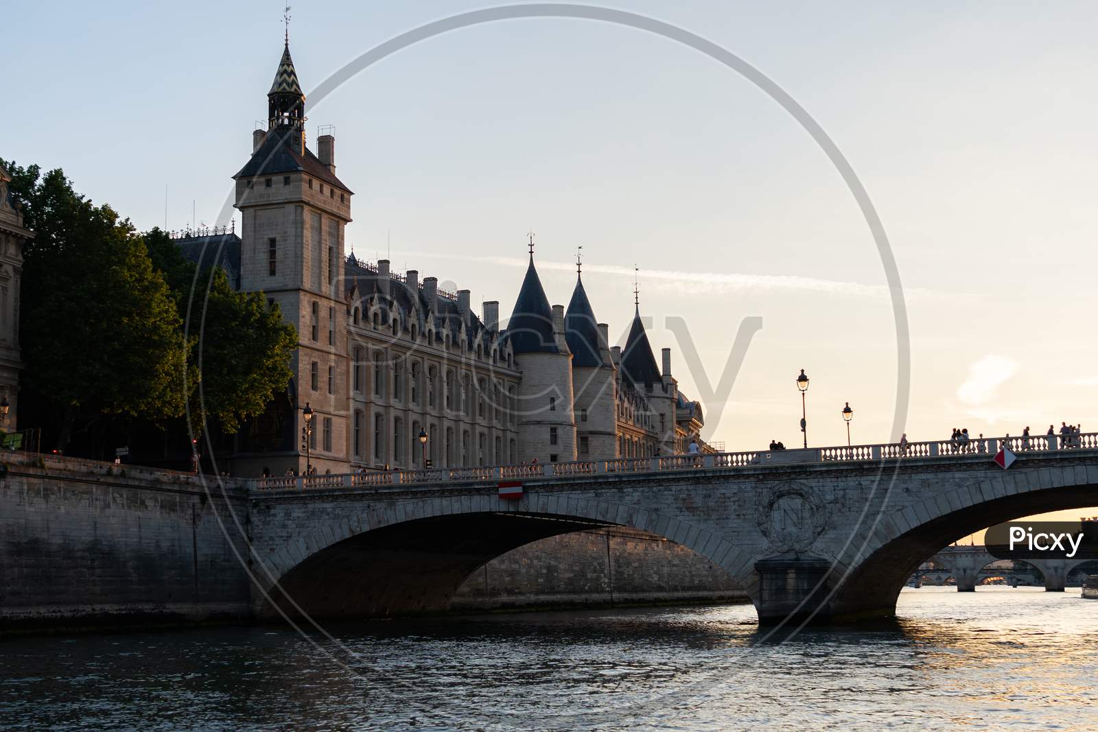 The Conciergerie And The Bridge Pont Au Change Seen From The Seine River In Paris France At Sunset.