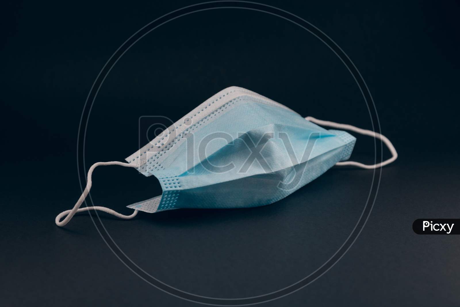 Close up from Surgical mask for protection against the pandemic. Covid-19 protective measures. Blue mask on black background.