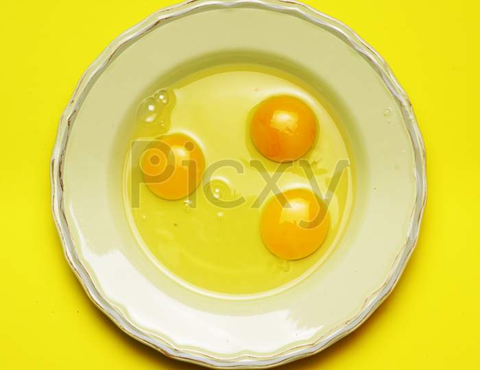 Raw Eggs On Green Plate And Yellow Background. Cooking Concept. Flat Lay. Flat Design