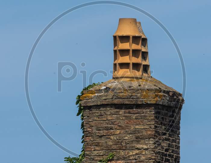 Stylish aged Chimney pot stack against blue sky