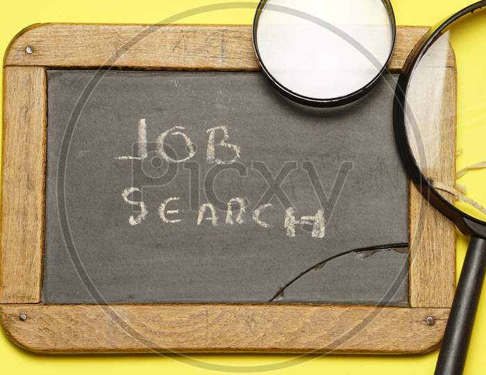 Black Chalkboard With Job Search Message With Two Magnifying Glasses. Flat Lay.