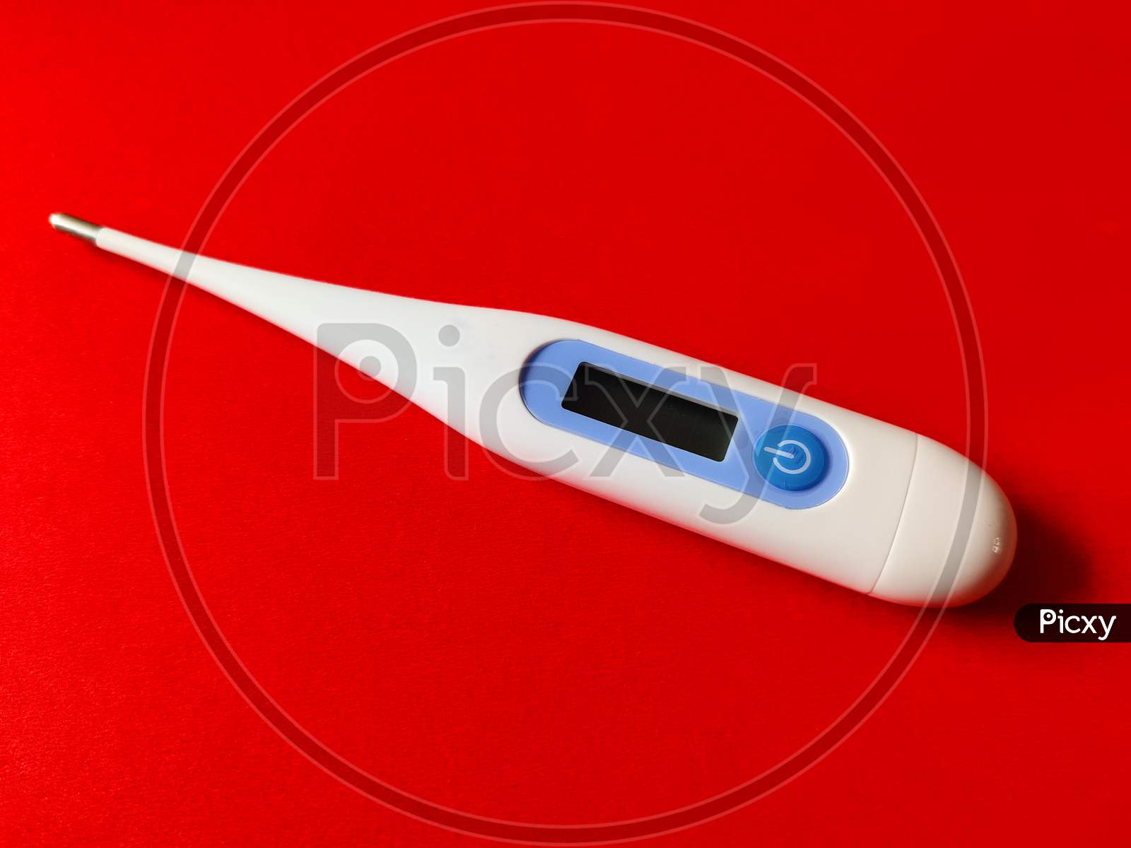Digital Thermometer For Measuring Temperature. Isolated On Red Background.