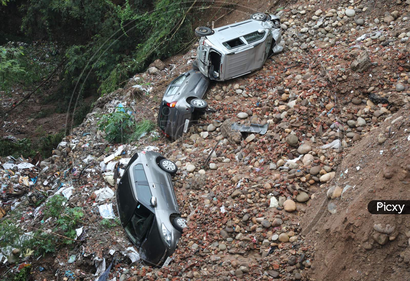Vehicles lying damaged in a ditch after heavy rains resulted in sinking of a roadside along circular road connecting Panjtirthi with Gujjar Nagar in Jammu city  on August 17,2020.
