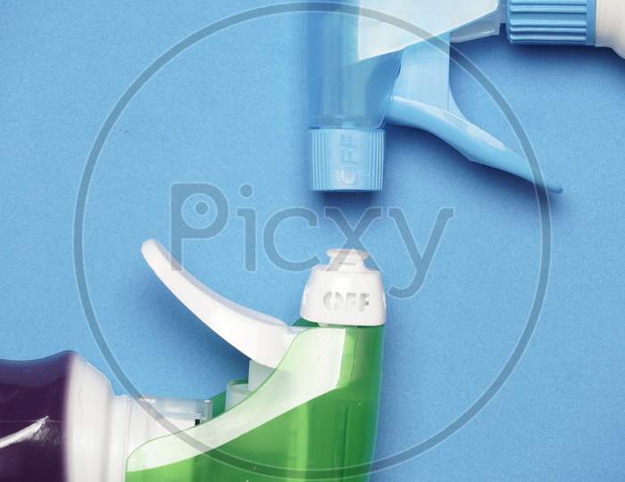 Flat Lay Of Cleaning Products On Blue Background. Home Cleaning Concept