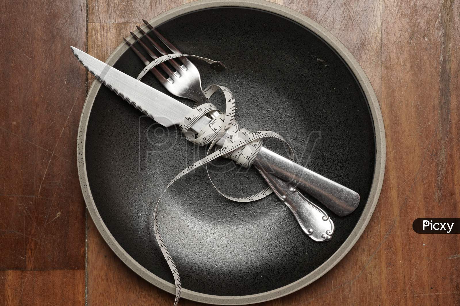 Empty Plate On Wooden Background With Cutlery And Measuring Tape. Diet Concept.