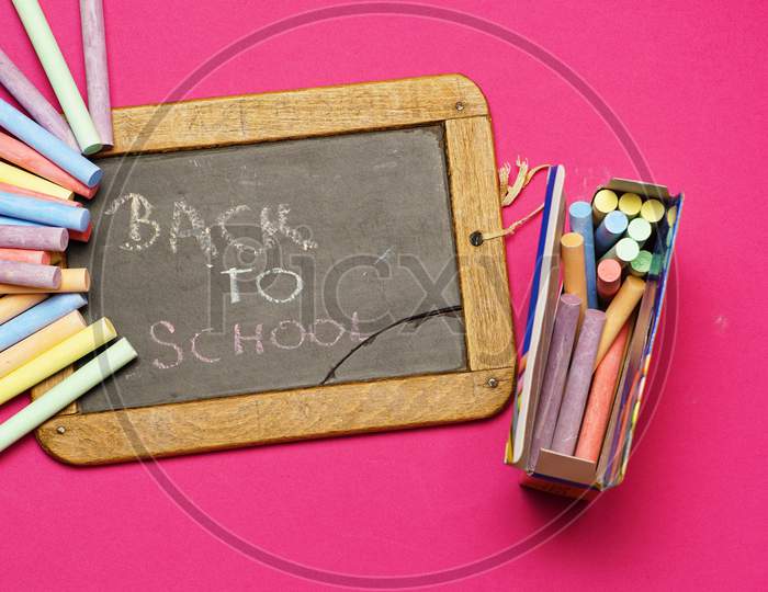 Top View Of Blackboard With Chalks And Back To School Message. Flat Lay. Flat Design