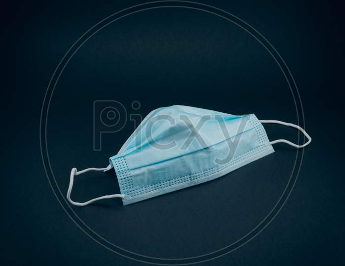 Close up from Surgical mask for protection against the pandemic. Covid-19 protective measures. Blue mask on black background.