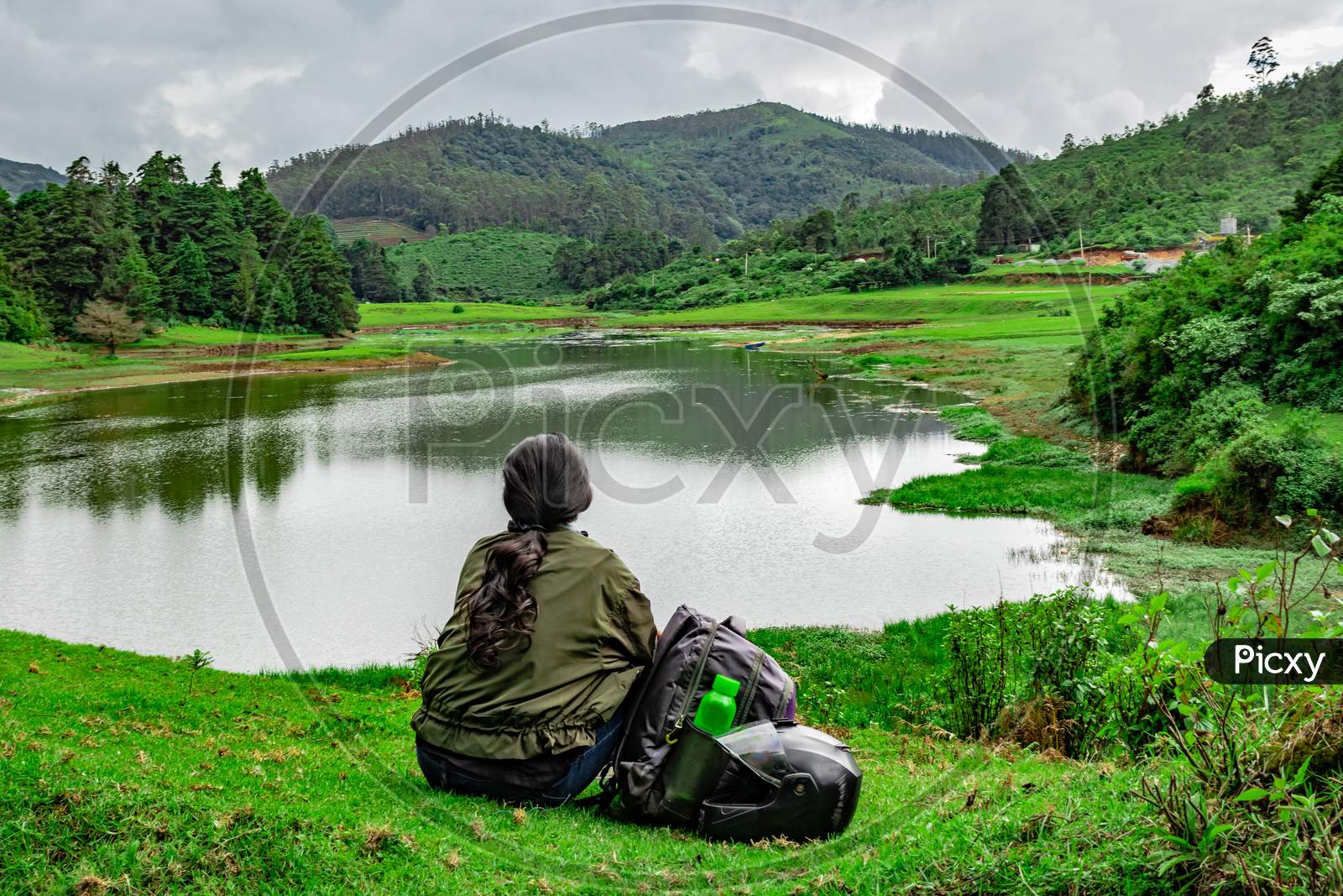 Girl Isolated Sitting At Serene Lake With Lush Green Forest