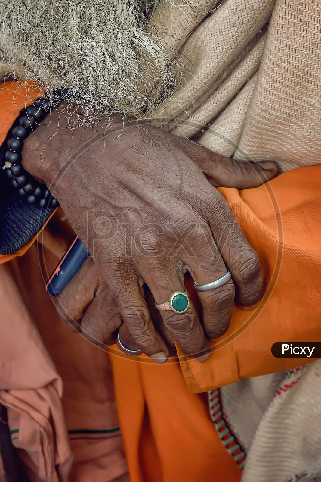 The old hands of a sadhu - holy man of India seen on the sidewalk in Varanasi.