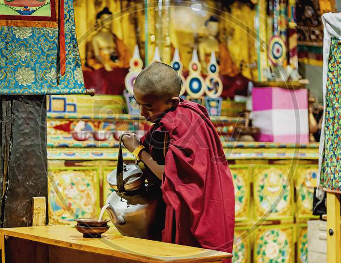 A young monk student boy serving early morning breakfast at Tiksey Monastary
