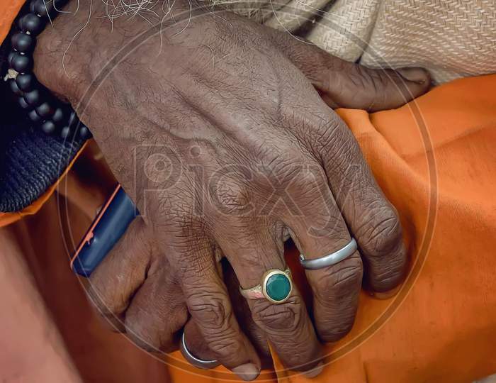 The old hands of a sadhu - holy man of India seen on the sidewalk in Varanasi.